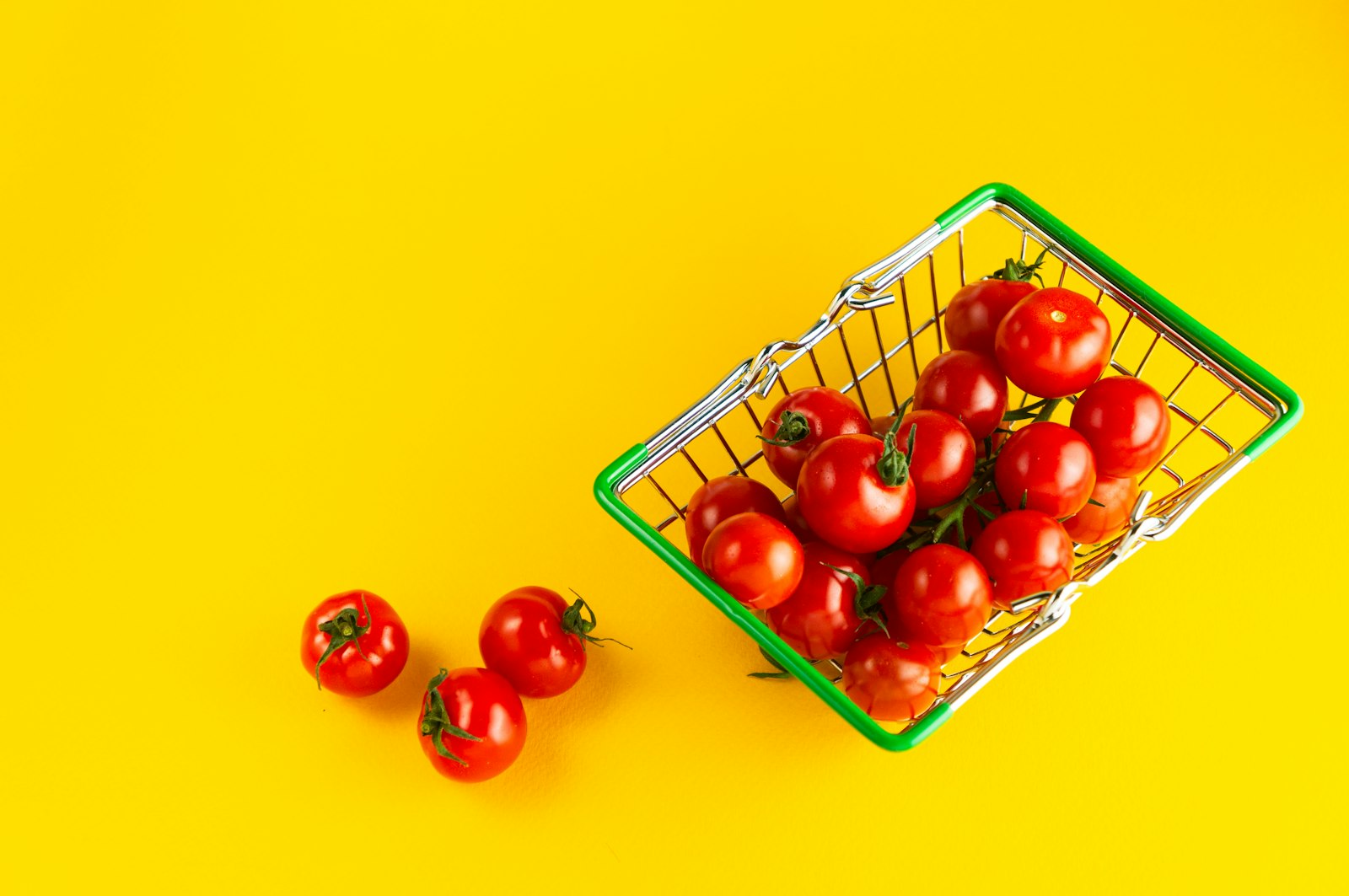 노란 배경 위 초록 장바구니에 담긴 방울토마토